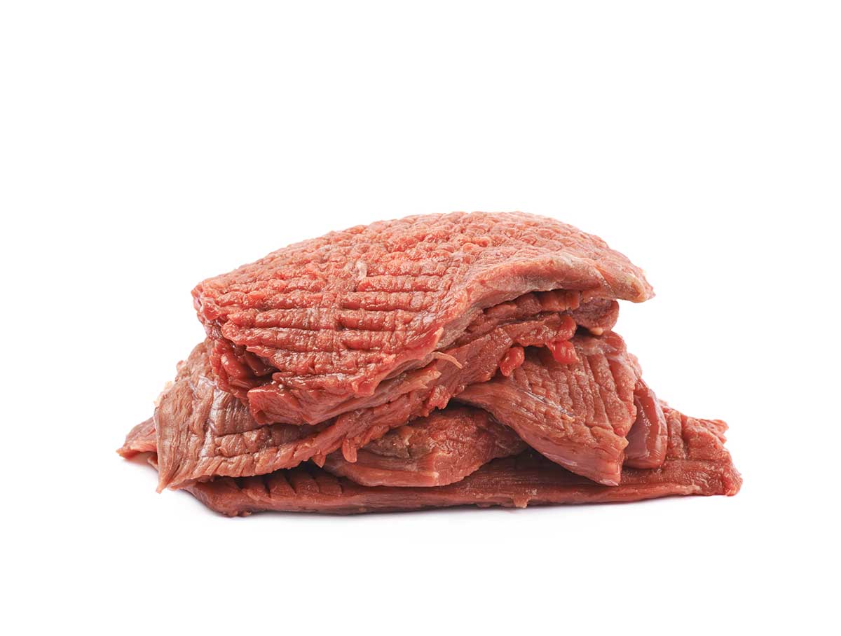  of multiple tenderized slices of raw beef meet isolated over the white background"